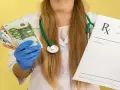 Lekarz w rękawiczkach trzyma banknoty euro i receptę. Kto płaci za zwolnienie lekarskie w firmie powyżej 20 osób?