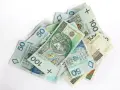 Stos banknotów 50 i 100 zł. Czy premia uznaniowa może pokryć koszty chorobowe?