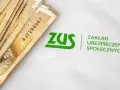 Pieniądze i logo ZUS. Symbolizują wsparcie finansowe podczas pobytu w szpitalu w trakcie świadczenia rehabilitacyjnego.