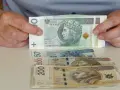 Ręce trzymają stos banknotów 100 zł. Pod spodem leżą banknoty 50, 500 i 200 zł. Pytanie: co po zasiłku rehabilitacyjnym?
