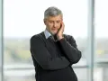 Pracujący rencista zamyślony, jakby rozważał zwolnienie lekarskie.