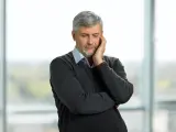 Pracujący rencista zamyślony, jakby rozważał zwolnienie lekarskie.