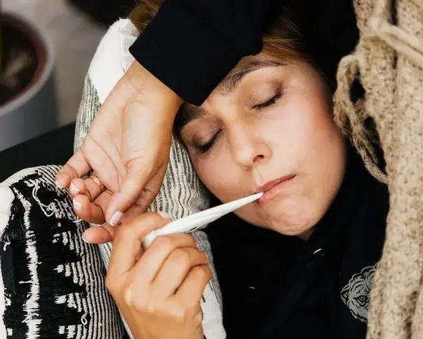 Kobieta z gorączką mierzy temperaturę. To ważny element przy ustalaniu podstawy wymiaru zasiłku chorobowego.
