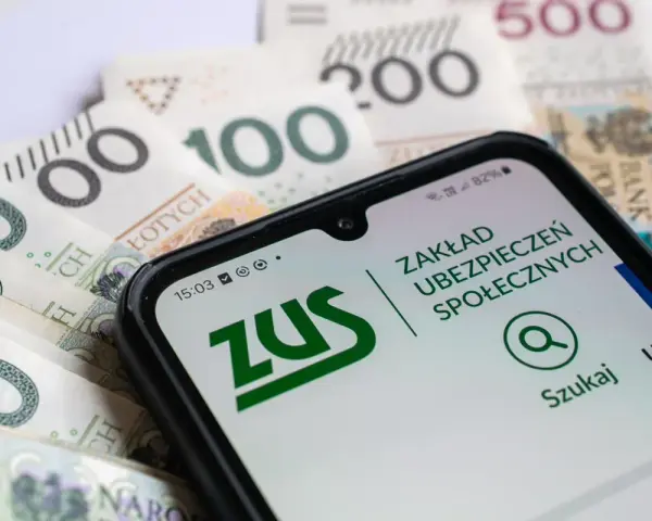 Telefon z aplikacją ZUS na tle polskich banknotów. Czy bezrobocie wlicza się do emerytury? Sprawdź na ZUS.