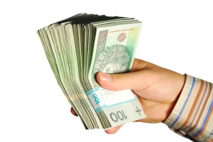 Dłoń trzyma plik banknotów 100 zł. Taka kwota z ubezpieczenia chorobowego przysługuje w wielu sytuacjach.