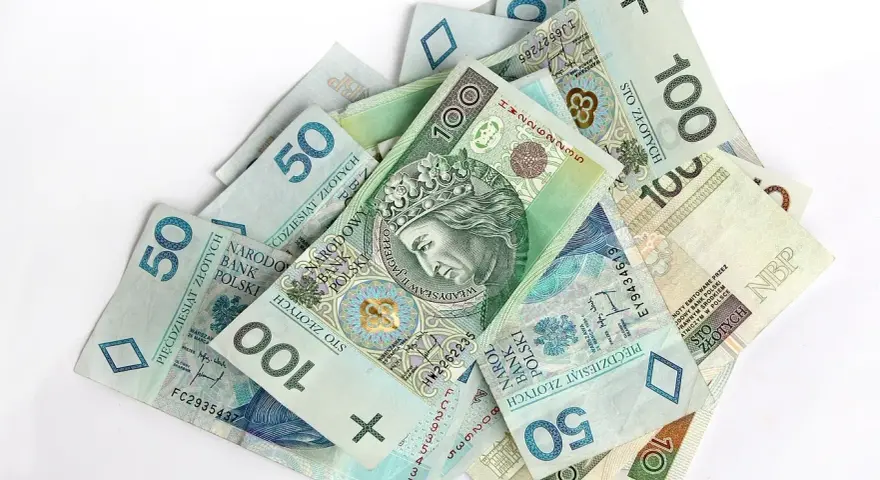 Stos banknotów 50 i 100 zł. Czy premia uznaniowa może pokryć koszty chorobowe?