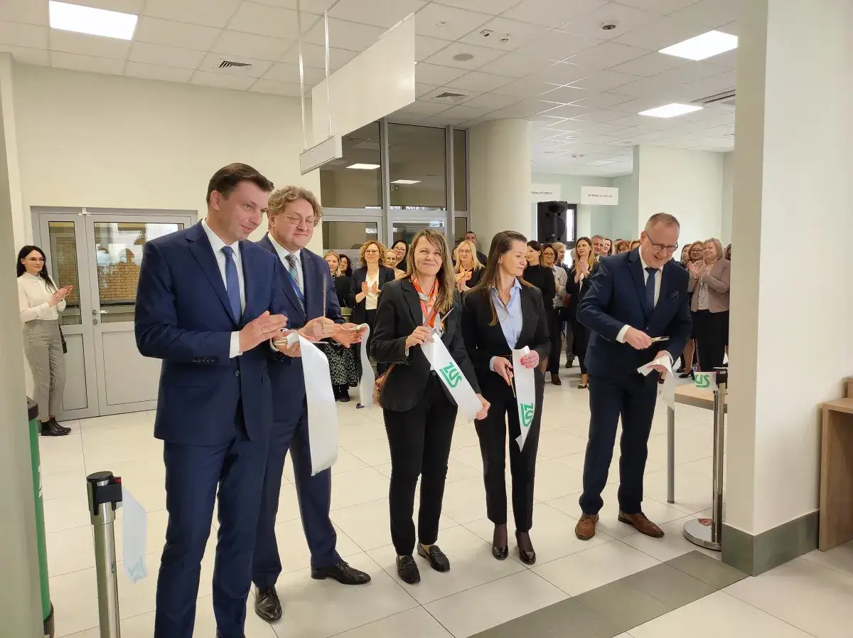 Uroczyste otwarcie nowej placówki ZUS w Białymstoku. Dyrektorzy przecinają wstęgę, a pracownicy i goście klaszczą.