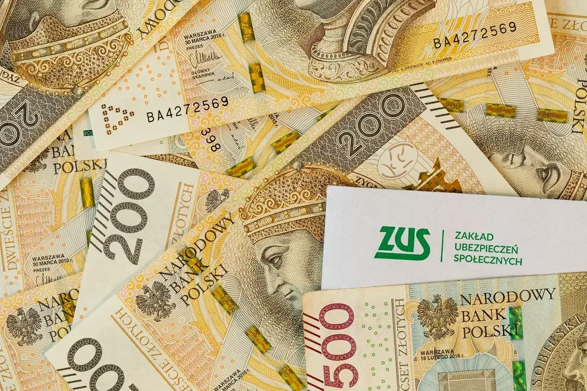 Złotówki i logo ZUS. Pieniądze i staż pracy to klucz do przyszłej emerytury.