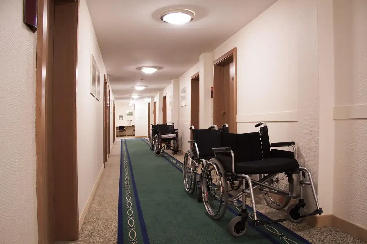 Korytarz z wózkami inwalidzkimi, gotowymi na czas po zasiłku rehabilitacyjnym.