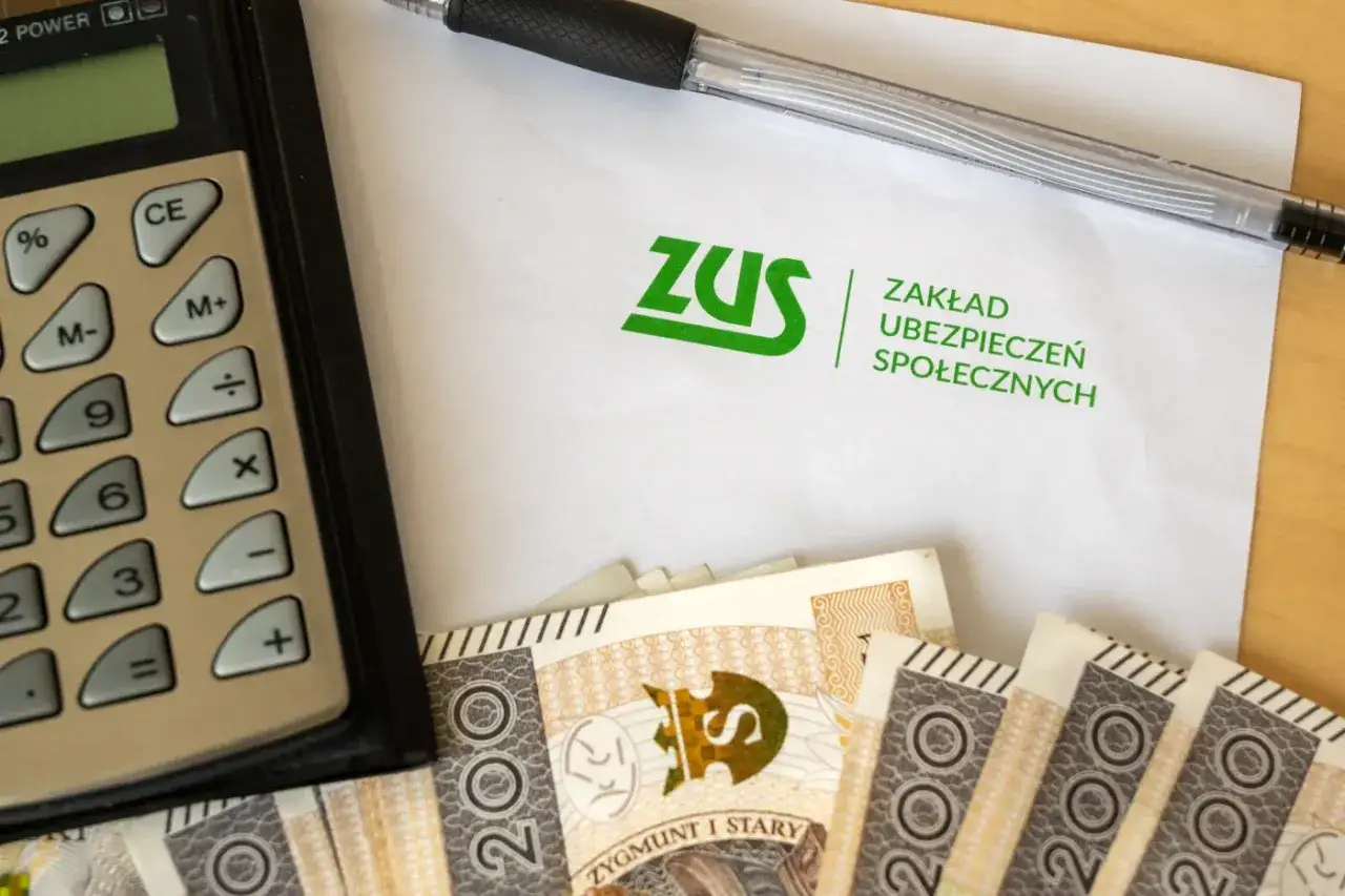 Kalkulator, długopis, dokument ZUS i pieniądze. Temat: dwóch pracodawców a zwolnienie lekarskie.