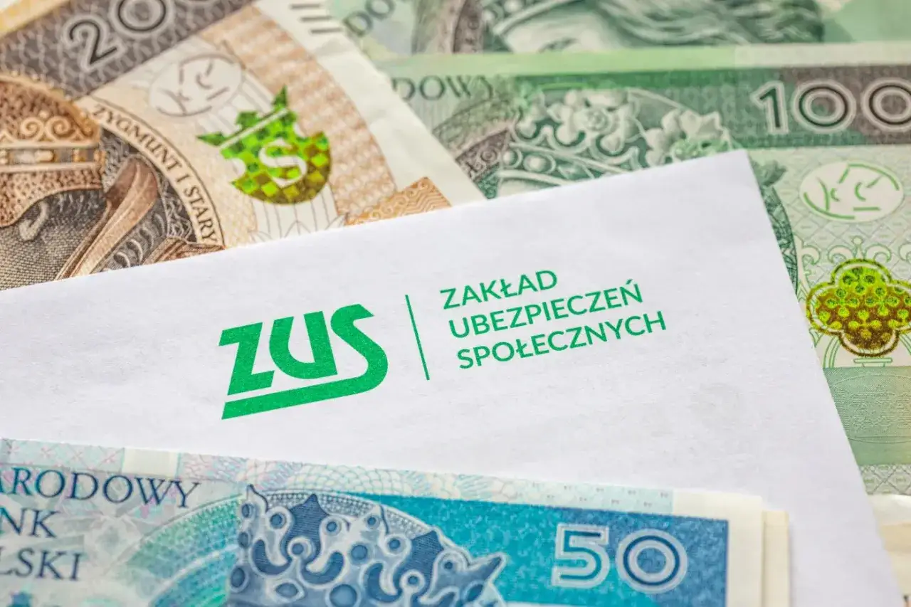 Koperta ZUS na tle polskich banknotów. Czy kuroniówka wlicza się do stażu pracy? Pytanie o świadczenia i staż pracy.